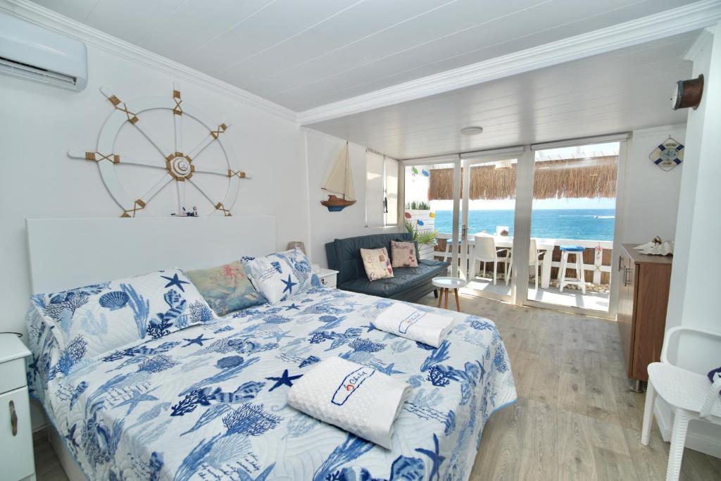 a bedroom with a blue and white bed with a large clock at Seaside Beach Chalet in Anfeh PEARL in Anfah
