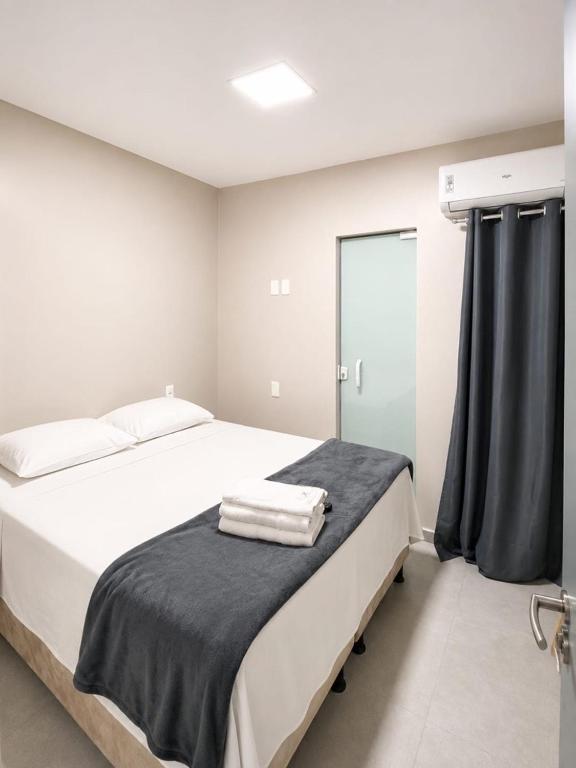 a bedroom with a large white bed and a window at Hotel Campina Center in Campina Grande