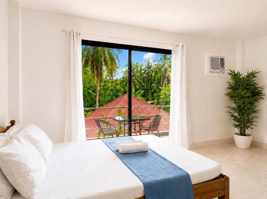 a bedroom with a bed with a view of a balcony at Yayay Siargao - Generator & Starlink in General Luna