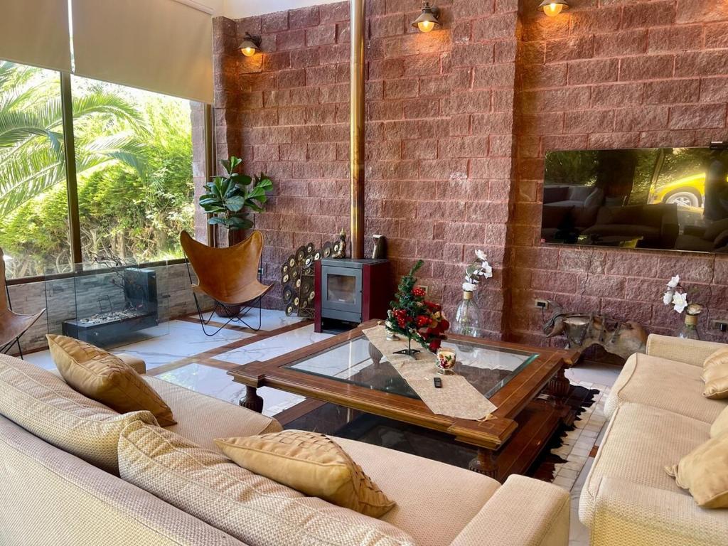 a living room with two couches and a fireplace at Casa Lago Colbun in Talca