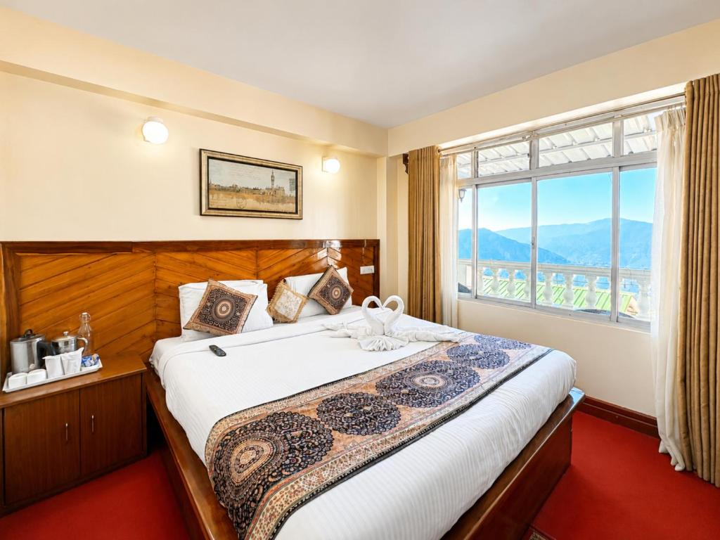 a bedroom with a large bed with a window at Hotel White Yak Darjeeling in Darjeeling