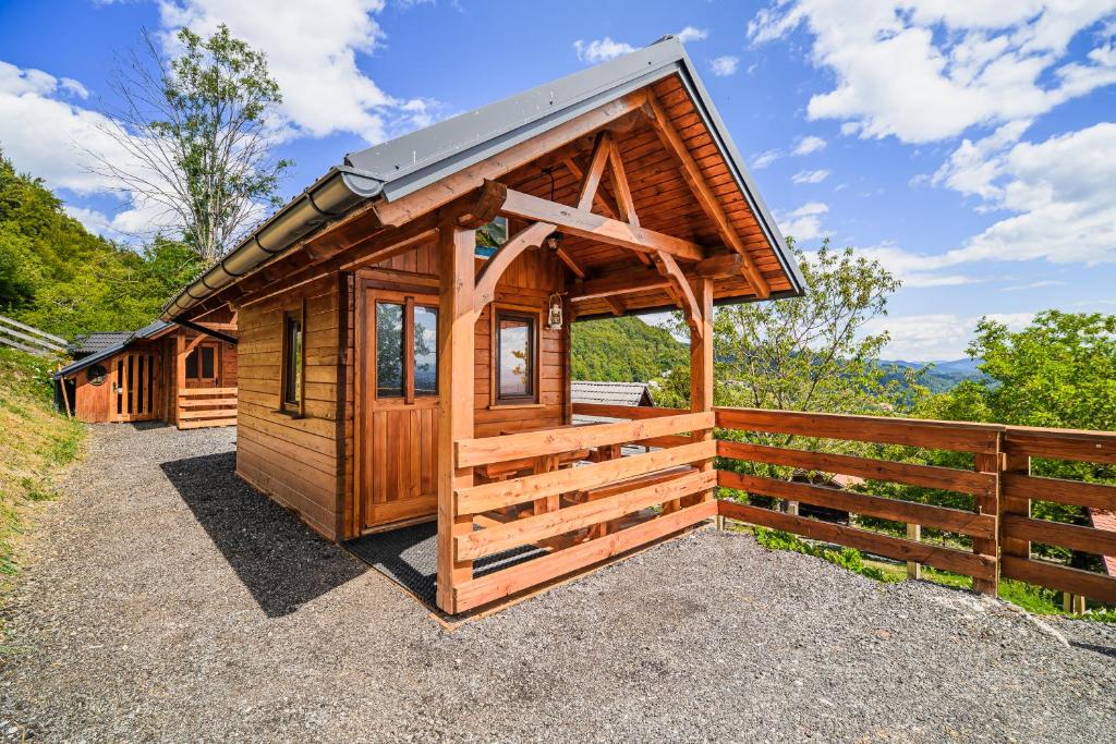 a wooden cabin with a fence in the background at Tiny Panorama Cottages in Kamnik