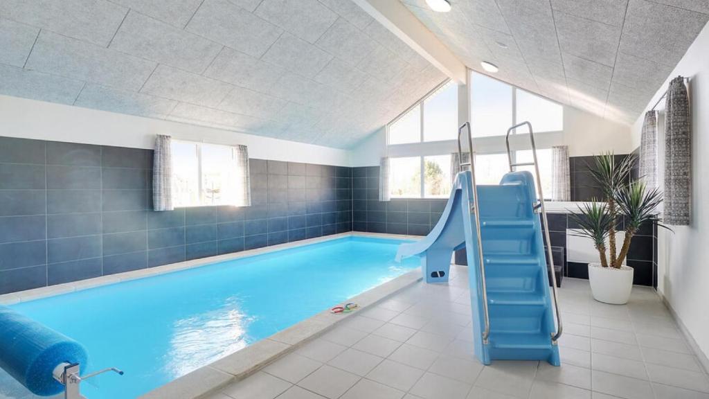 a swimming pool with a blue slide in a bathroom at Villavilla 446 - Grenå Strand, Østjylland in Grenå