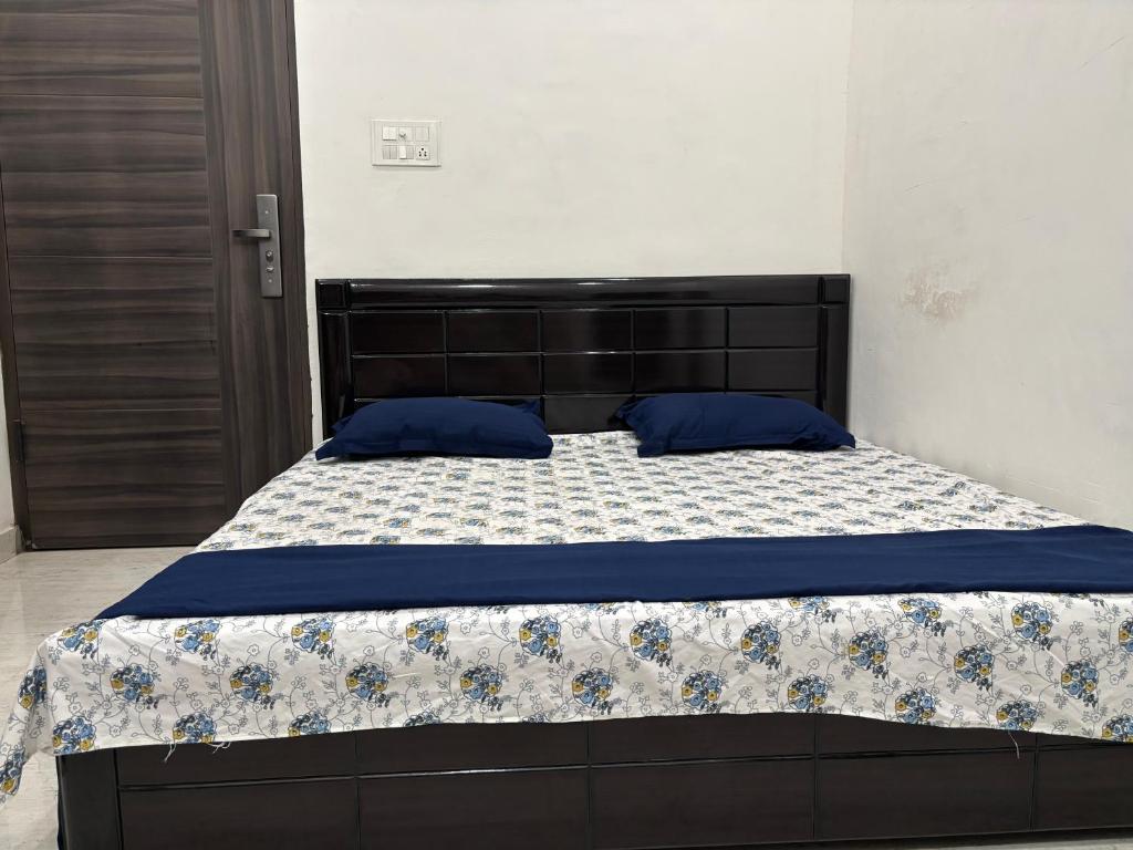 a bed with blue pillows on it in a bedroom at Bliss in Datia