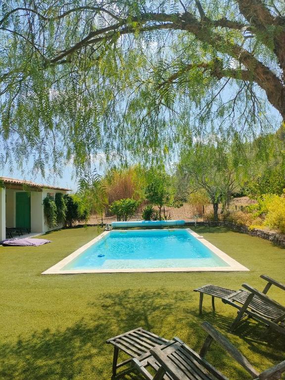 a swimming pool in a yard with two chairs at Emplacement idéal dans le Var ! in Cuers