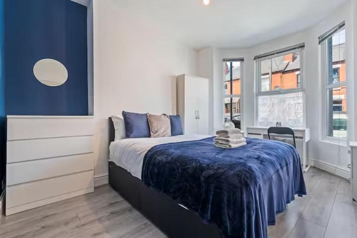 a bedroom with a bed with a blue blanket on it at Coventry Contractor Hub - 4-Bedroom House with Free Parking-CV5 in Spon End