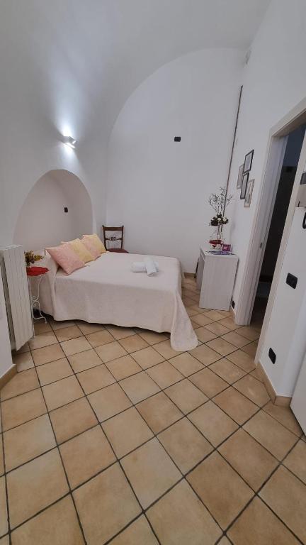 a bedroom with a bed and a tiled floor at Dimora Suriano in Altamura