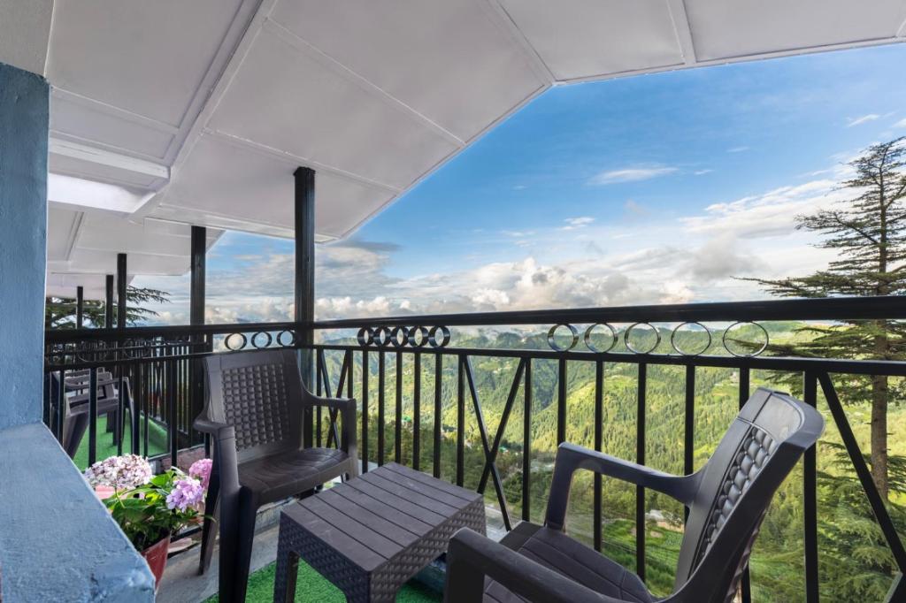 a balcony with chairs and a view of the mountains at The Ayura Palace l Family Events I Multi Cuisine Restaurant l Sky Bonfire l Lift l Power Backup l Free Parking l Kufri By Exotic Stays in Kūfrī