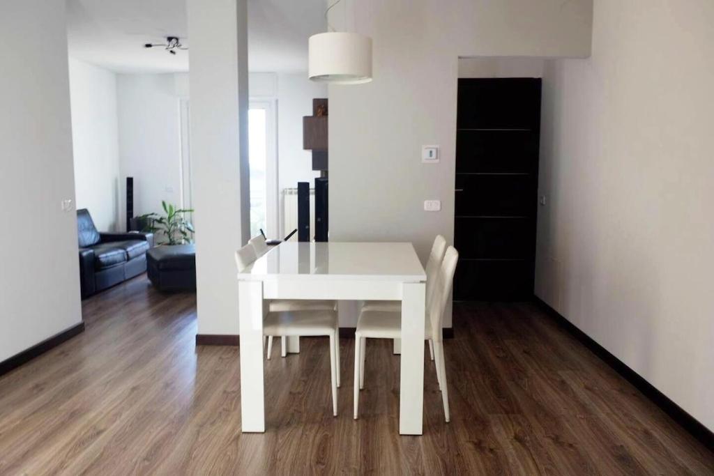 a white dining table and chairs in a living room at Malpensa-Milano, Terrazza, 2 Bagni in Galliate