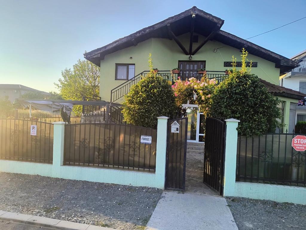 a house with a black fence and a gate at Casa Dyny 2 Mai in 2 Mai