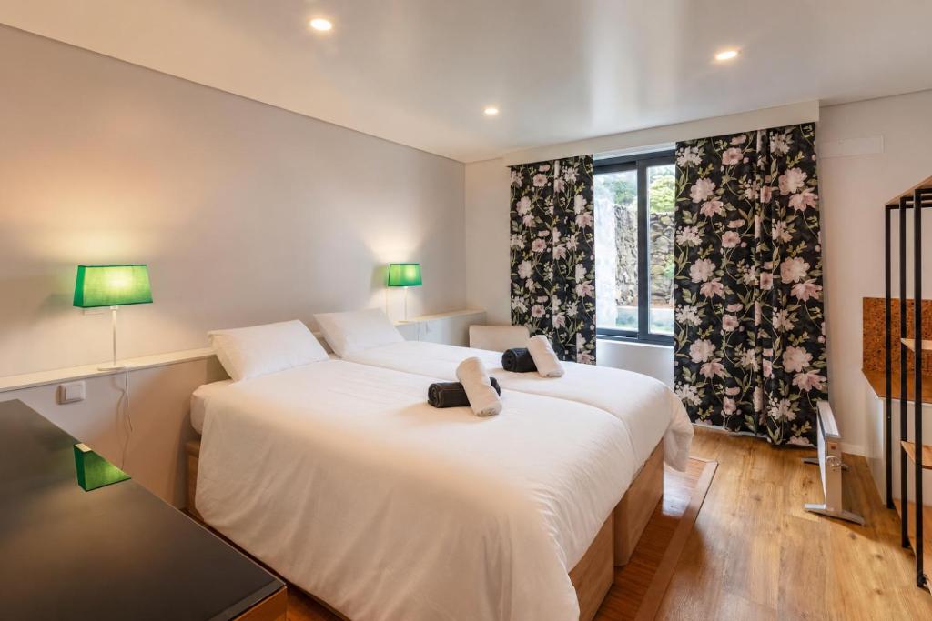 a bedroom with two beds and a window at Your Azorean Home RRAL 3378 in Ribeira Grande