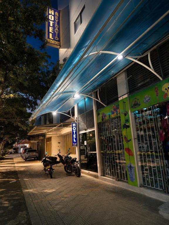 a motorcycle parked outside of a store at night at Hotel Rey David in Yopal