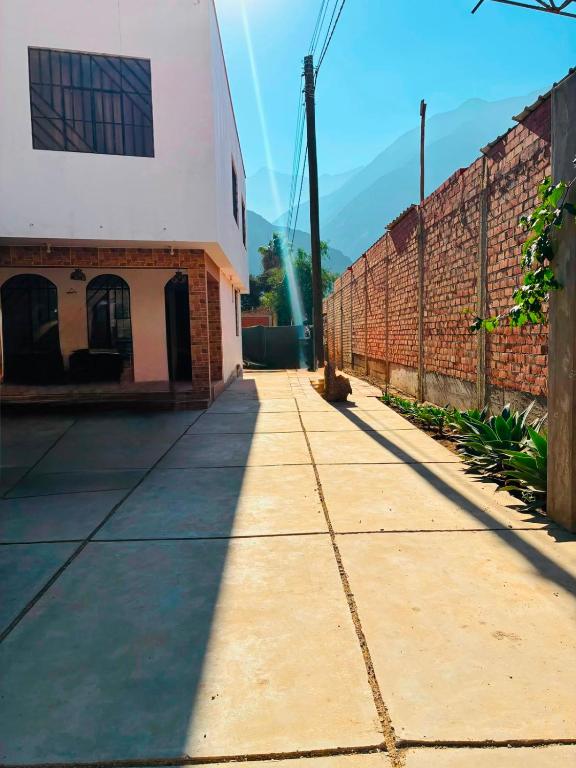 an empty sidewalk next to a brick building at La casa de Manuel in Lunahuaná