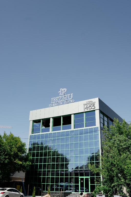 a building with a sign on the top of it at Inzhu Premium Hotel in Taraz