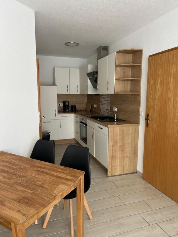 a kitchen with a wooden table and black chairs at Ferienwohnung Zweinig 06 in Zweinig