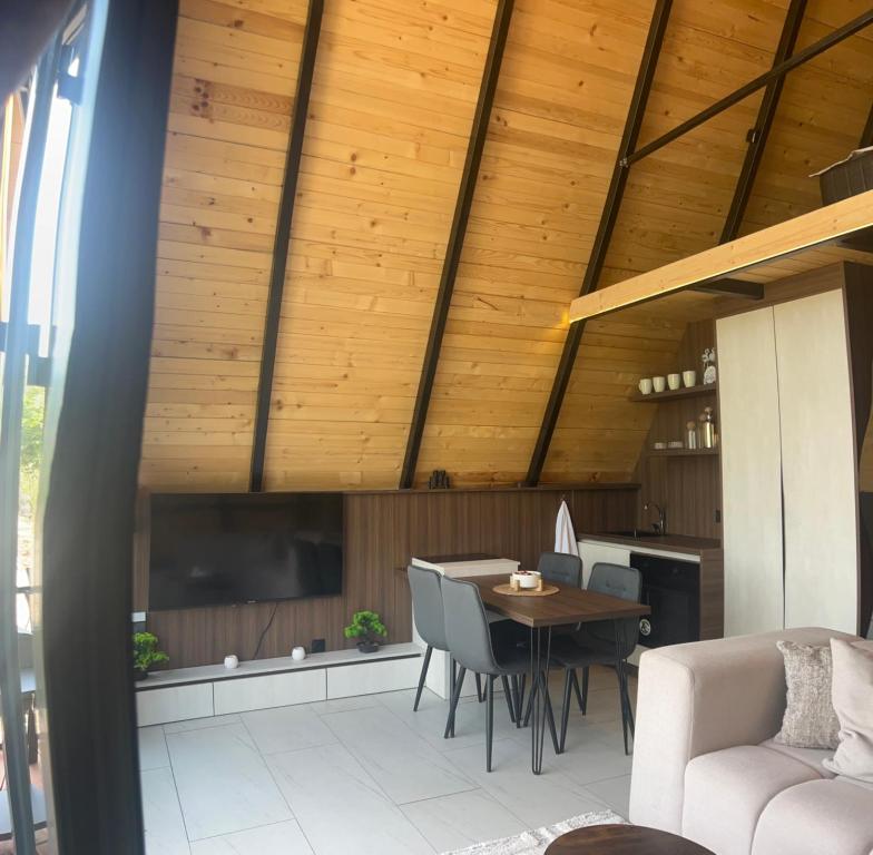 a living room with wooden ceilings and a table and chairs at LiLo s Villa in Ferizaj