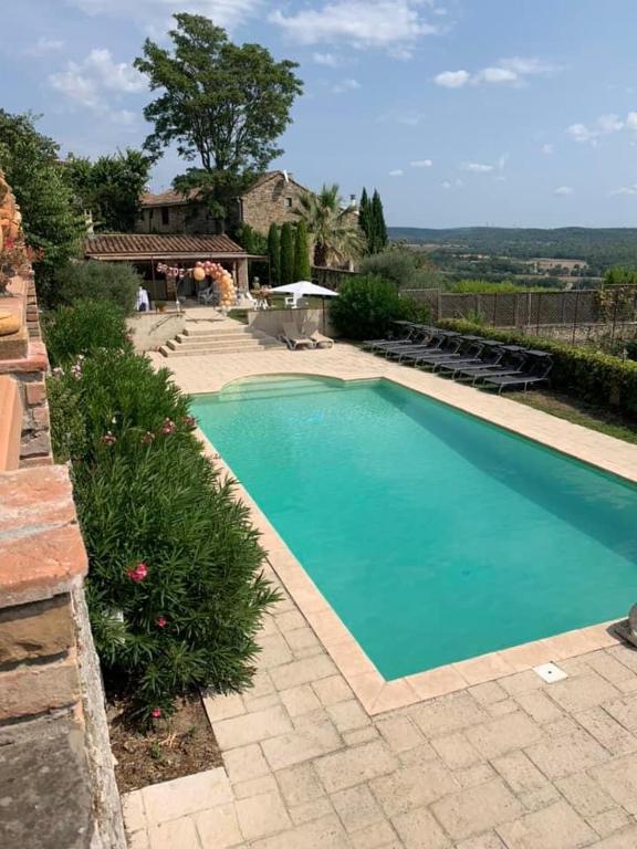 a swimming pool with blue water in a yard at Château de Mons Gard in Mons