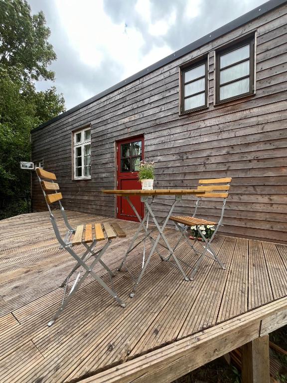 two chairs and a table on a deck with a house at Große Auszeit im Tiny House in Schashagen