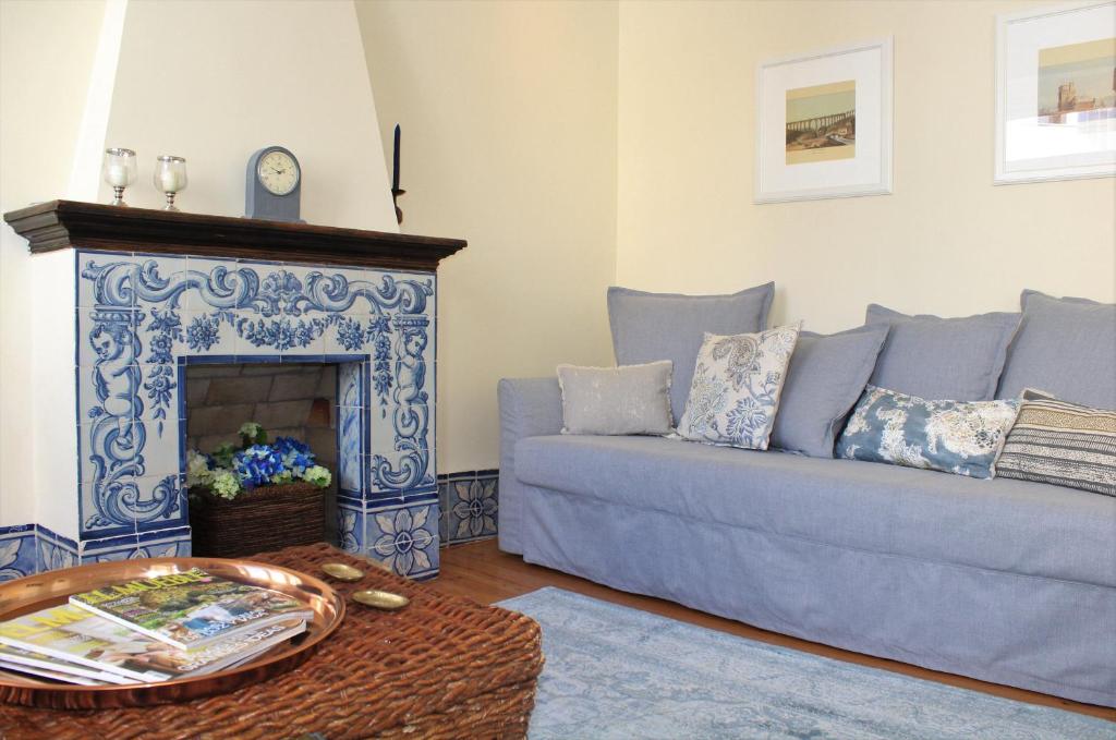 a living room with a blue couch and a fireplace at Charming Duplex- Príncipe Real in Lisbon