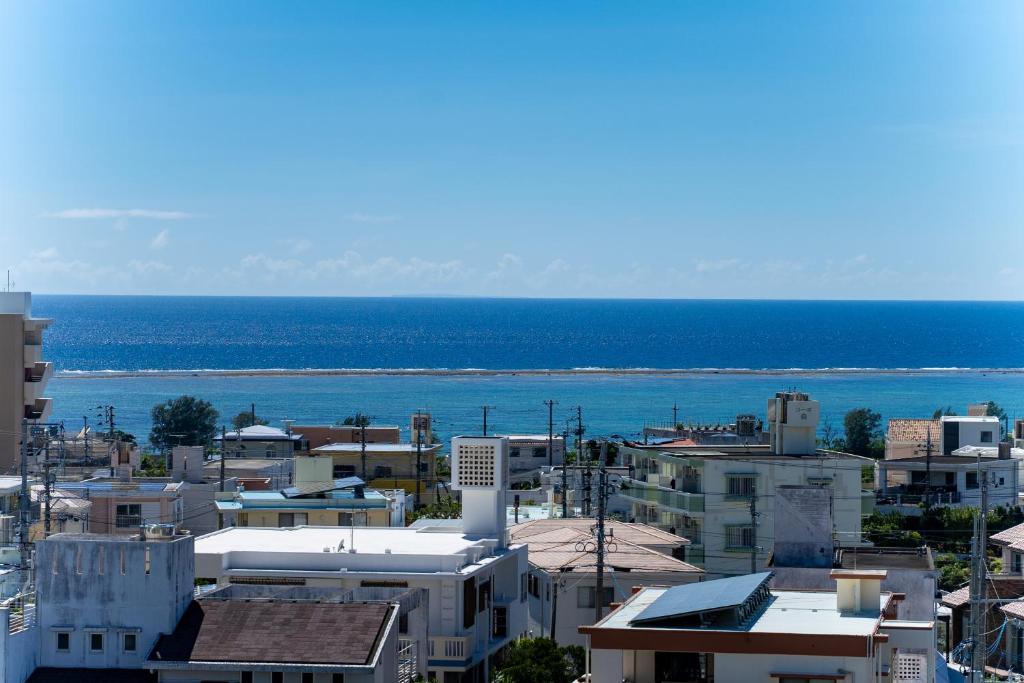 a city with buildings and the ocean in the background at Hotel Sunset ZANPA in Yomitan