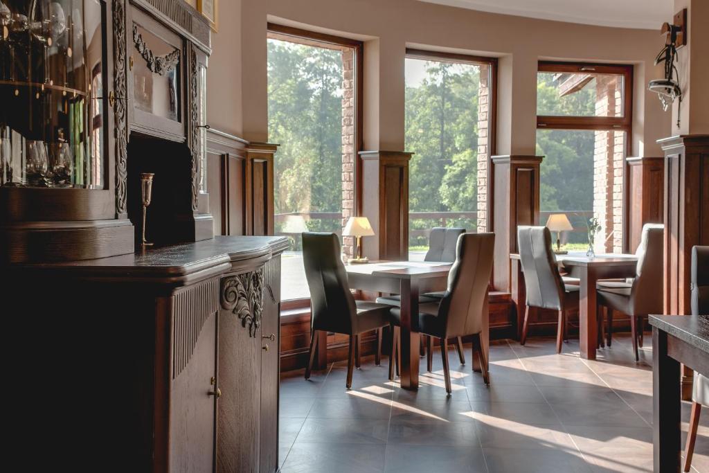 uma sala de jantar com mesas, cadeiras e janelas em Hotel Restauracja Biały Las Wierzbna em Żarów