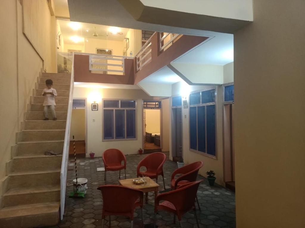 a person walking up the stairs in a room with chairs at Royal hotel jaglot gilgit in Gilgit