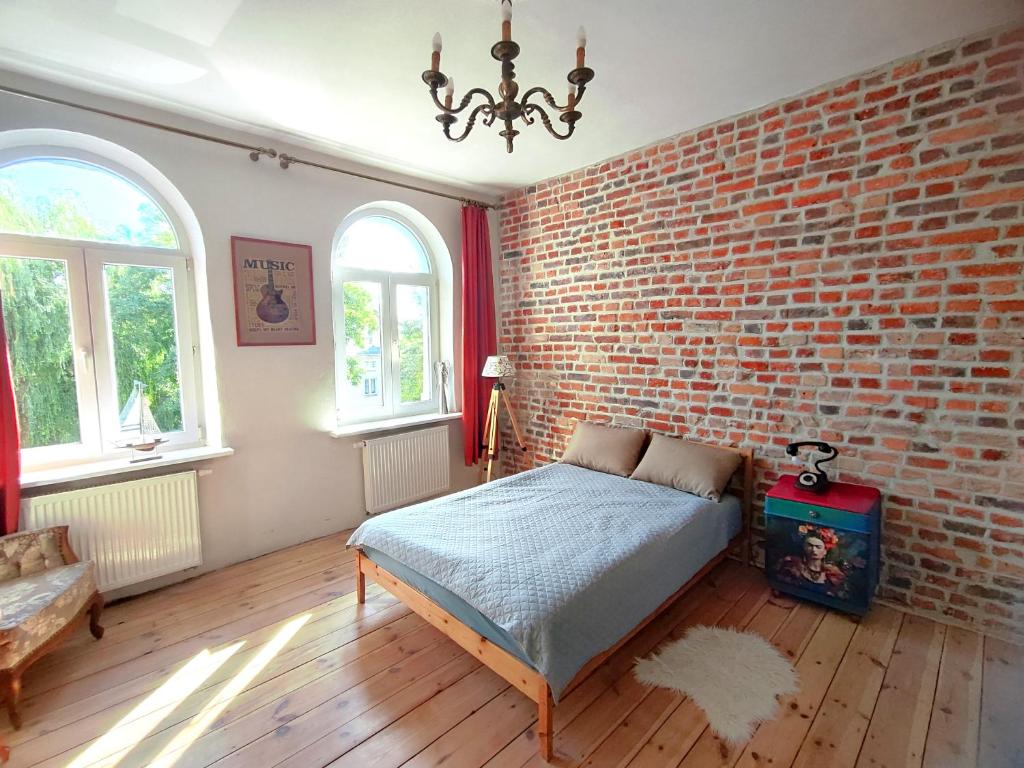 a bedroom with a brick wall and a bed at Kamienica u Artystów in Sopot
