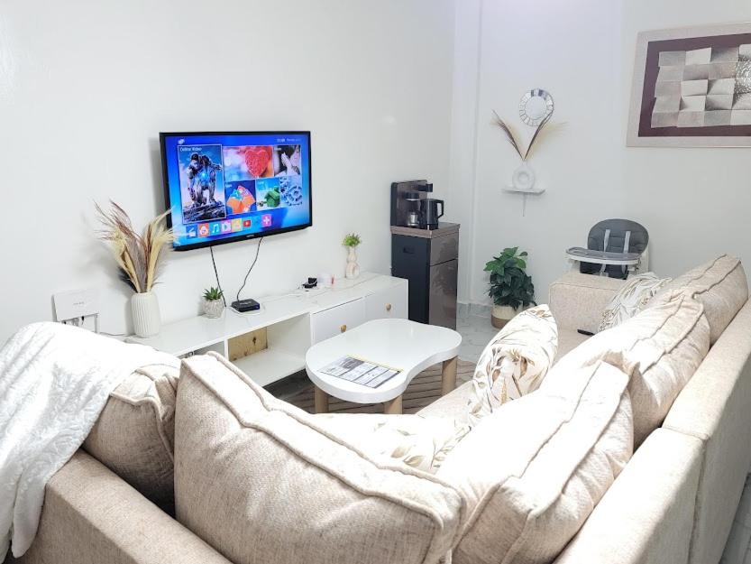 a living room with a couch and a tv at KilimaVista Homes 1 bedroom apartment in Kimana