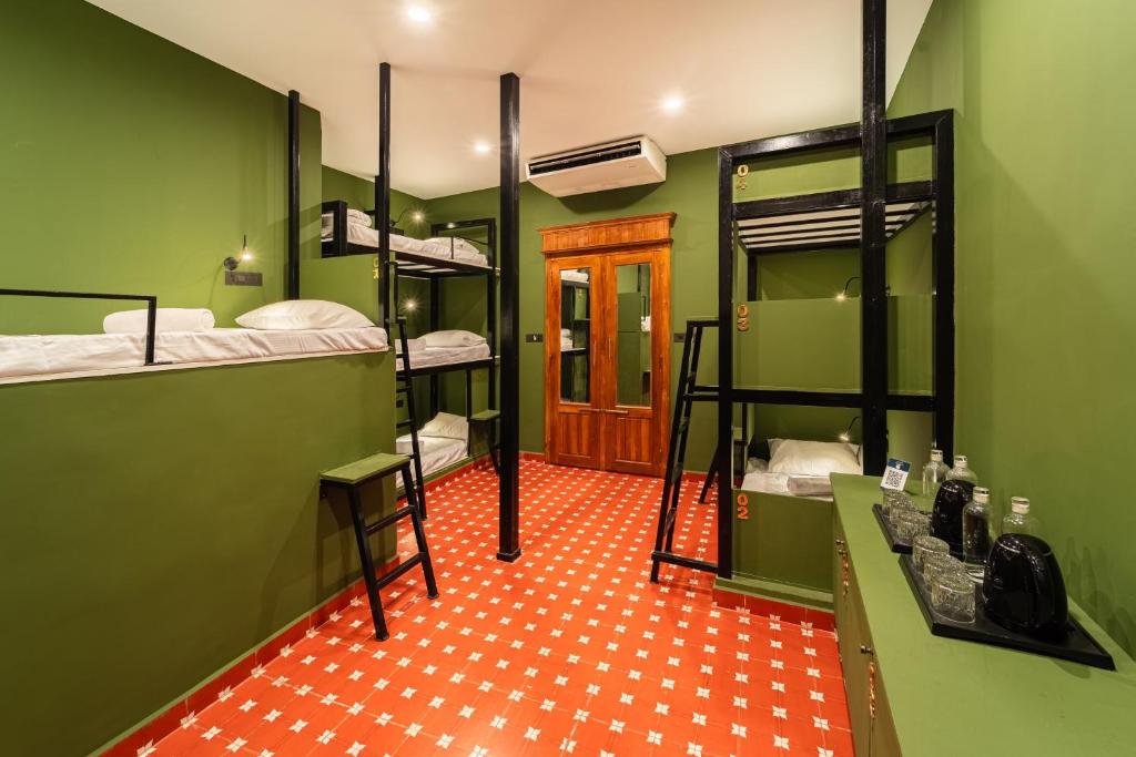 a room with four bunk beds and a red floor at Versailles Backpacker Hostel in Pondicherry