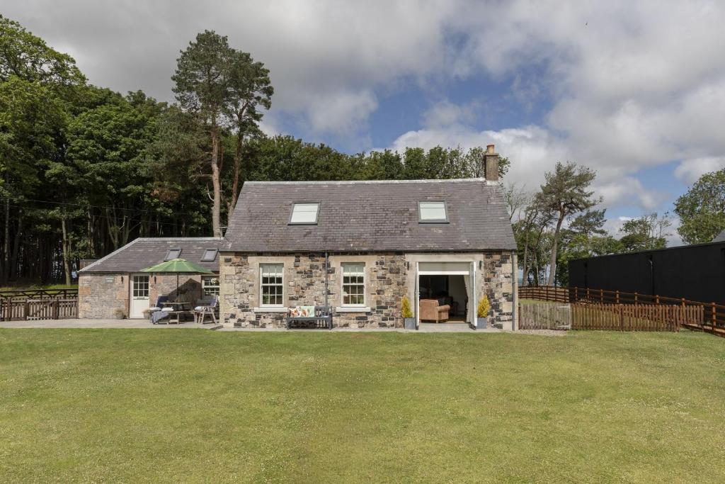 an old stone house with a yard at Greenhead Cottage in Kelso