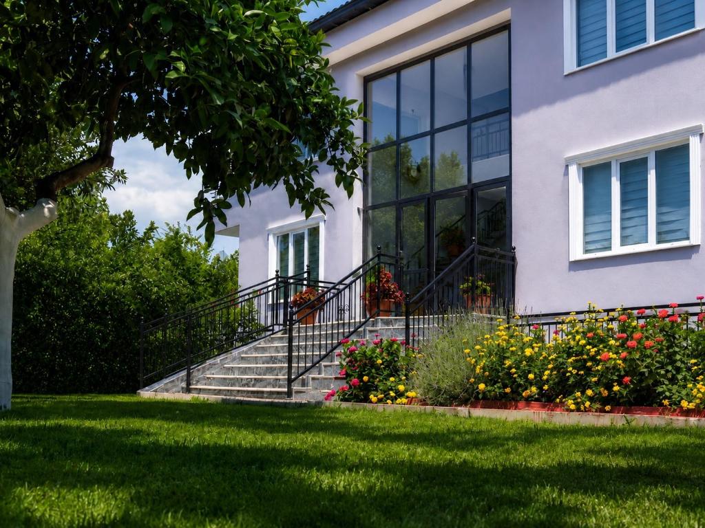 a house with stairs and flowers in the yard at Kagan Holiday Apartments in Kemer
