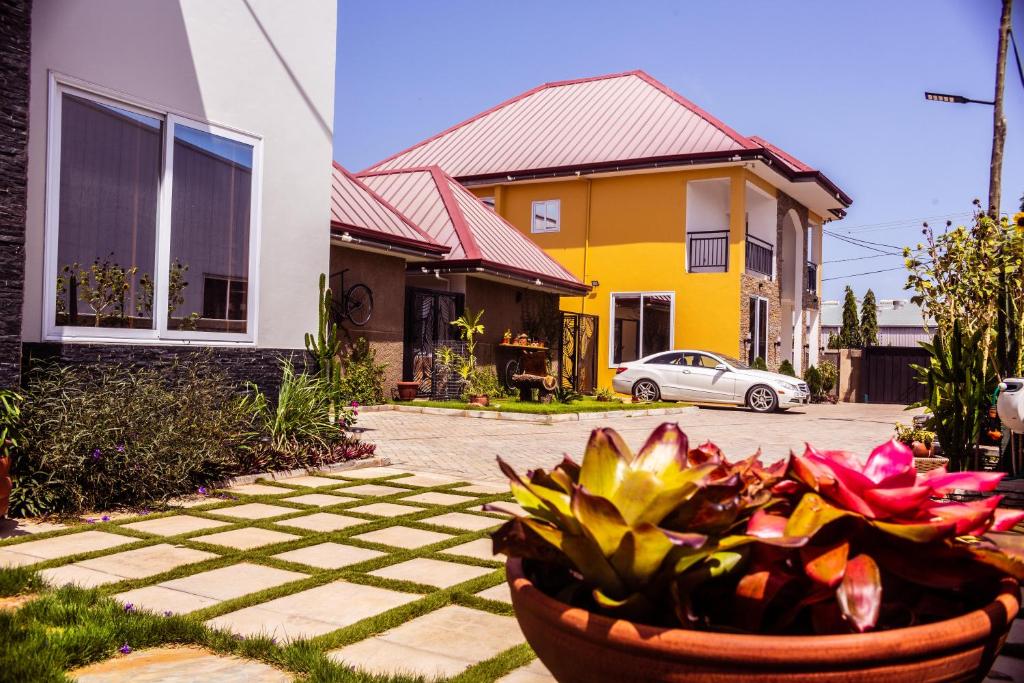a house with a bowl of flowers in front of it at Leaves & Stones in Kwedonu