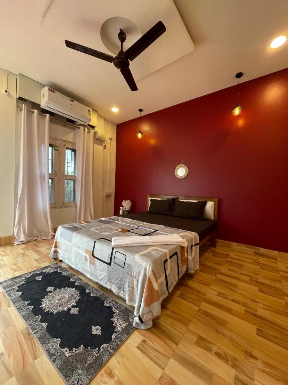 ein Schlafzimmer mit Bett und Deckenventilator in der Unterkunft Aroha Inn in Jorhat