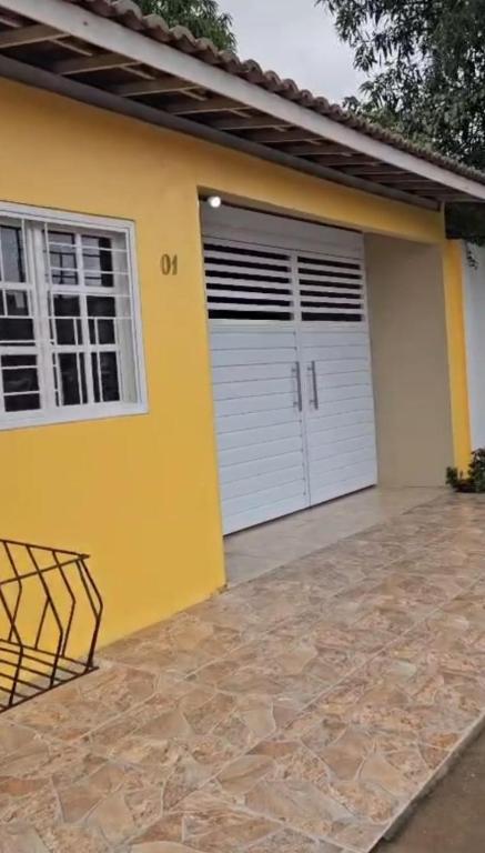 a yellow house with two garage doors at Casa de Charles in Piranhas