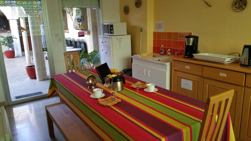 a kitchen with a table with a colorful table cloth on it at Chambres d&#39;hôtes et gîtes Al Pati in Sorède