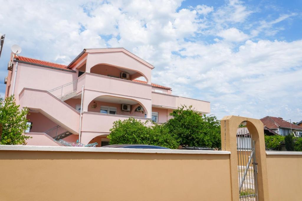 a pink house with a fence in front of it at BEB House Ulcinj in Donji Štoj
