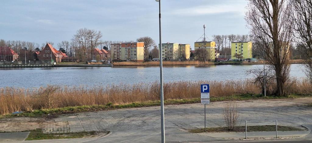 a street sign next to a river with buildings at Dziwnów 2 in Dziwnów