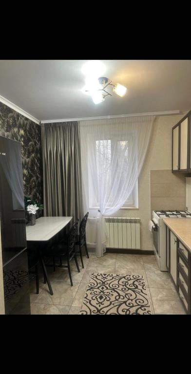 a kitchen with a table and a table and a window at AeroHome 24 -Внимание !!! Только дневное размещение !!! NO OVERNIGHT !!! Заселение с 12 00 и выселение до 23 00 !!! in Chişinău