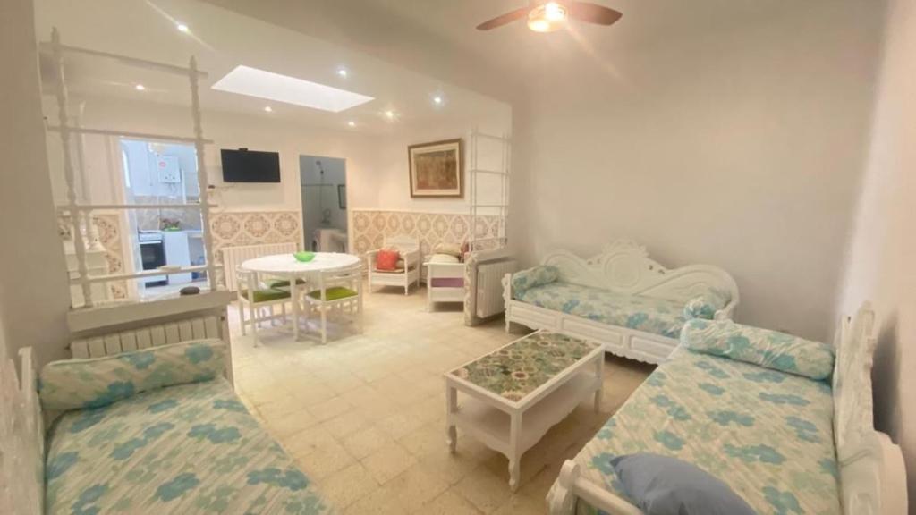 a living room with two beds and a table at Nice house ideally located in Dar Tahar Zaouch