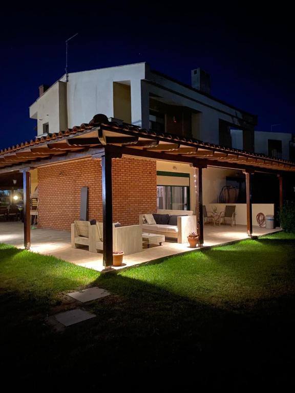 a house with an outdoor patio at night at Elthea Villa in Skala Fourkas