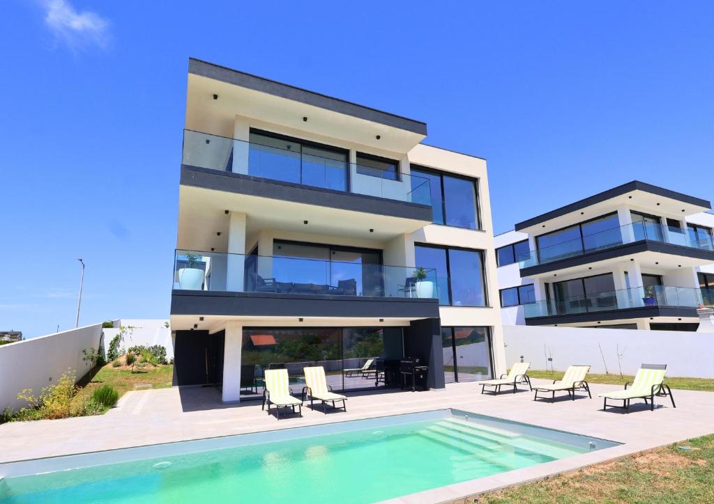 a house with a swimming pool in front of it at Villa Pingau in Vila Nova de Gaia
