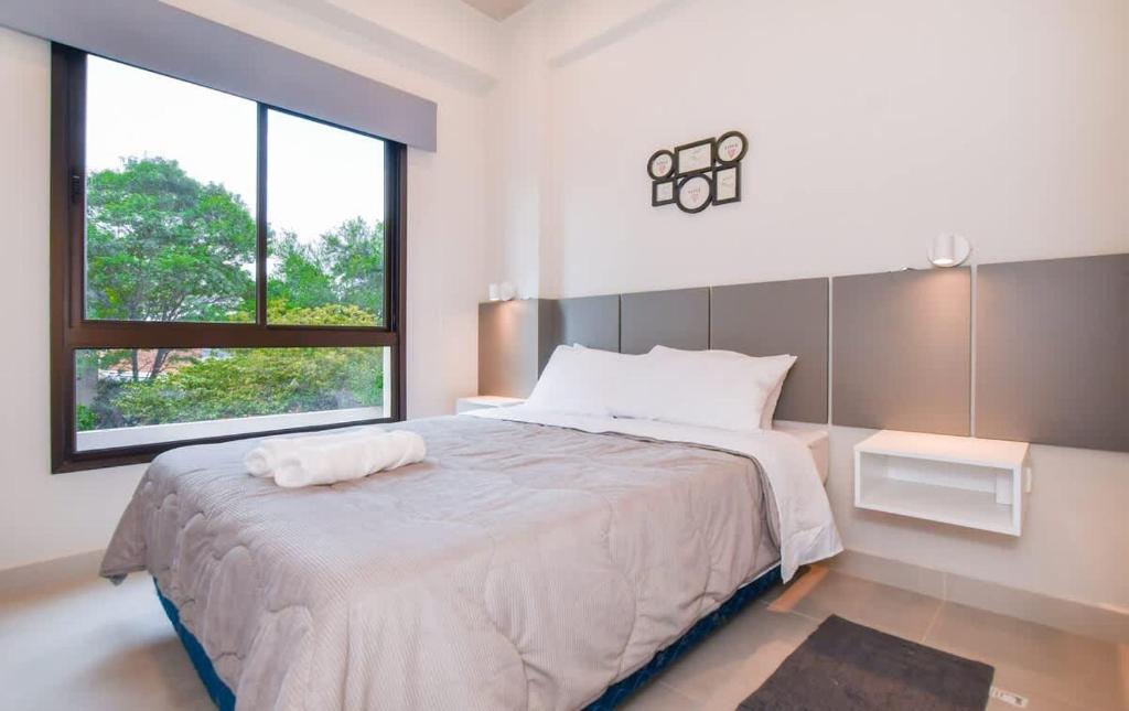 a white bedroom with a large bed and a window at Modern One-Bedroom for Work and Relax in Fernando de la Mora