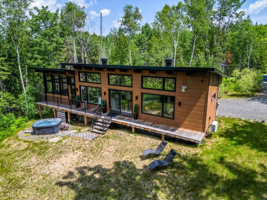 a cabin in the woods with a grill and a house at Le Clorane spa relax in Chertsey