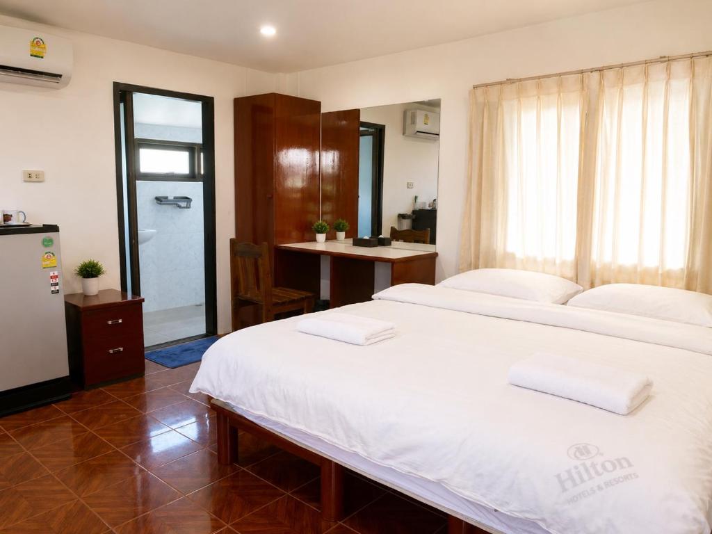 a bedroom with a large white bed and a desk at Baan Mon Hill in Patong Beach