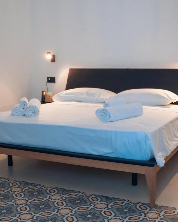 ein großes Bett mit blauen Laken und weißen Kissen in der Unterkunft Hotel Pietranera in Catania