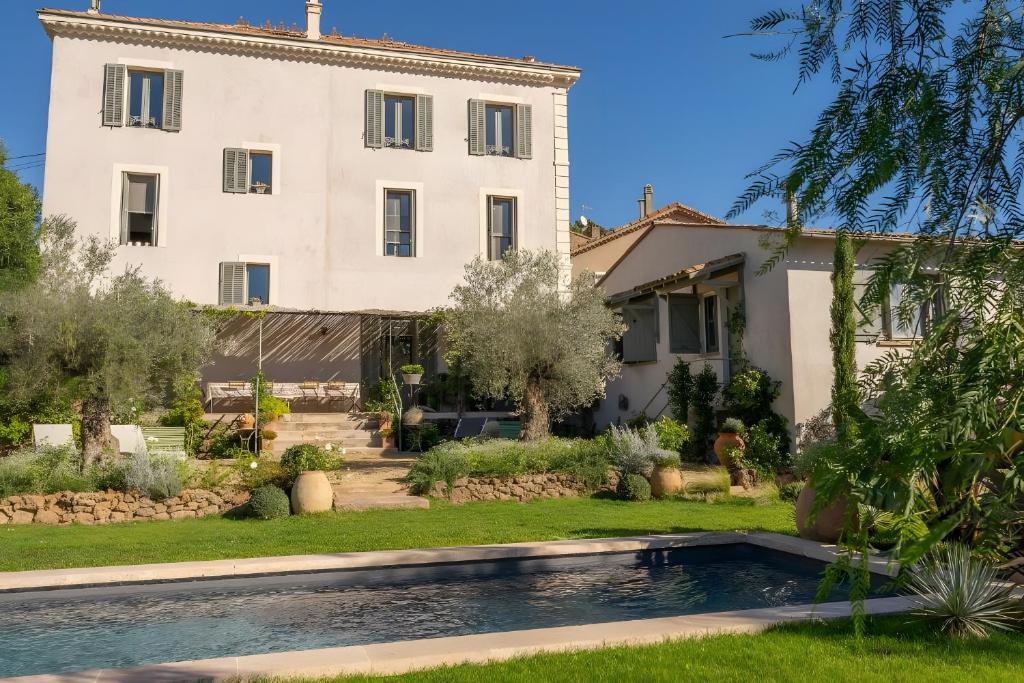 a villa with a swimming pool in front of a house at Maison Aimé in La Motte