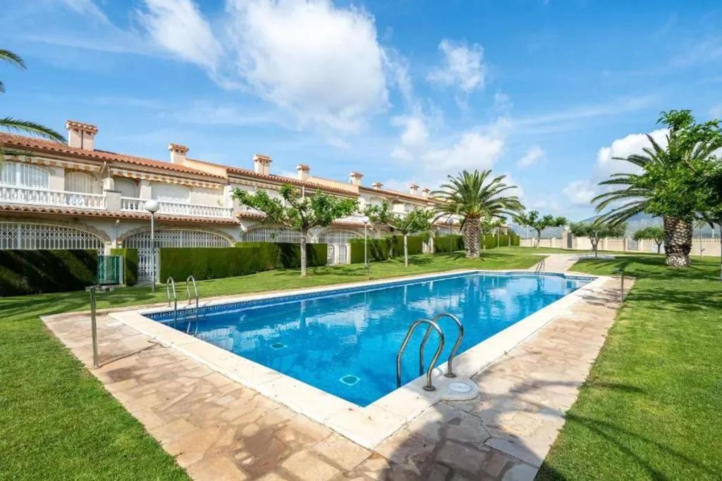 a pool in front of a house with palm trees at Apartment Miami Platja 80 m² Pool in Miami Platja