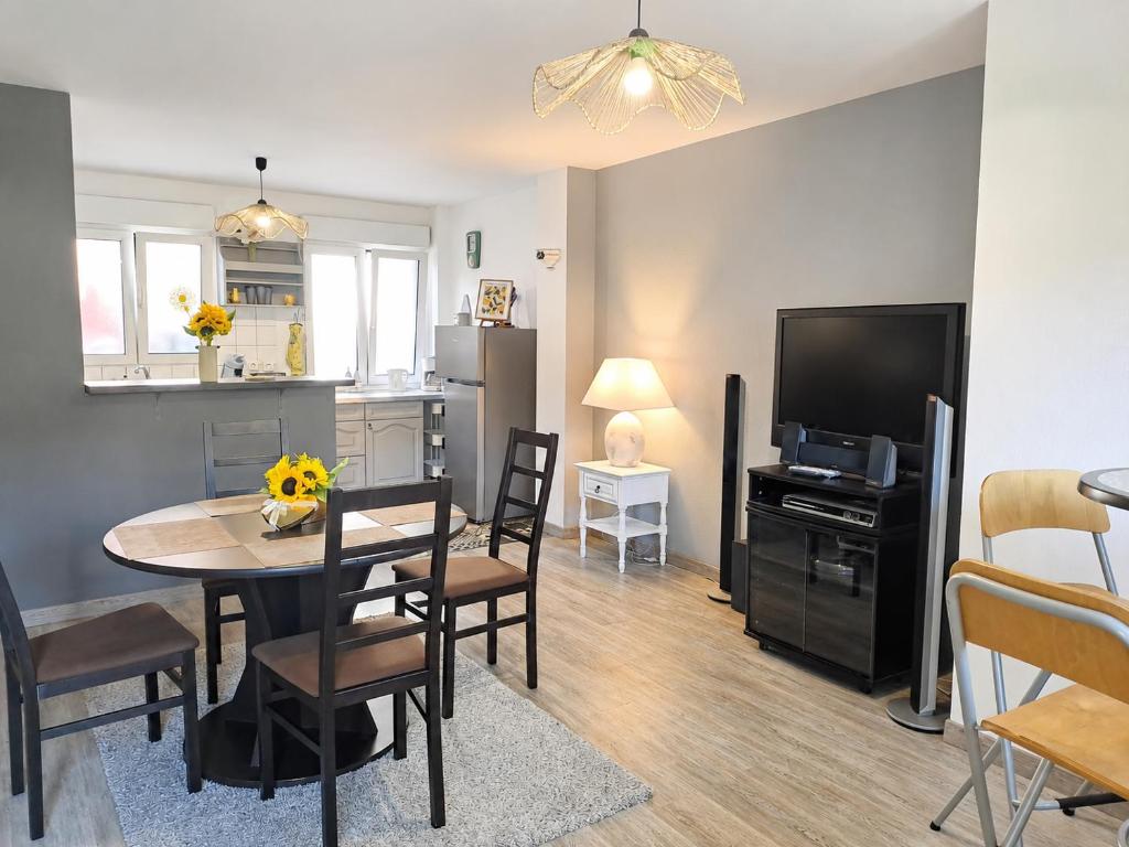 a kitchen and dining room with a table and a television at Duplex 2 à 4p. tout confort in Dolleren