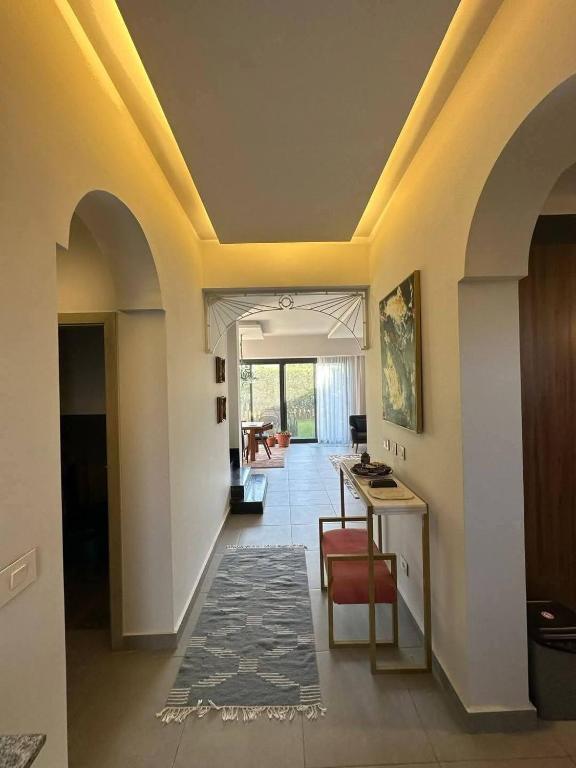 a living room with a hallway with a table and chairs at صفاء هاوس in Fāriskūr al Balad
