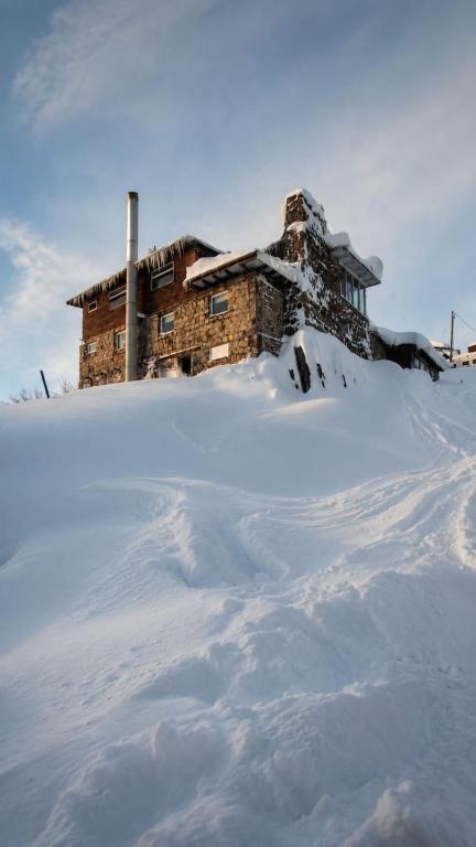 a house on top of a snow covered mountain at Cordillera Hostel in Farellones